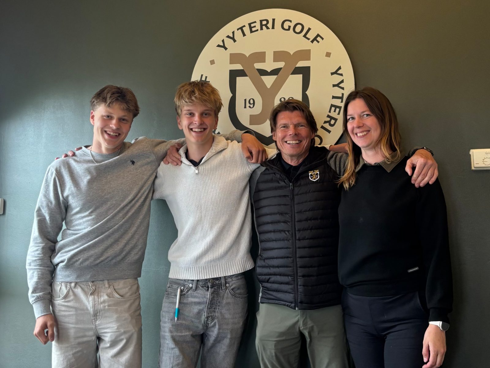 Leo Määttä ja Rasmus Rintamaa Pesuveljistä sekä Yyteri Golfin general manager Juha Harttunen ja caddiemaster Nina Toivanen klubitalolla seuran logon edessä